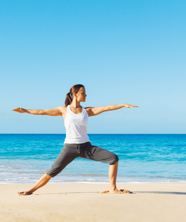 Woman doing yoga at the beach